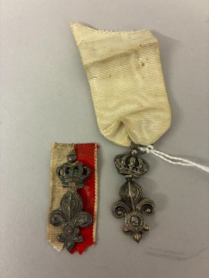 une vieille médaille avec un ruban et deux autres objets posés sur une table