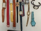 many different types of watches and pens laid out on a table