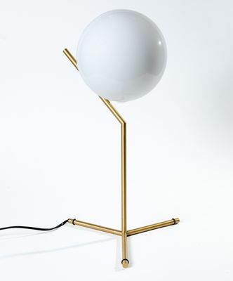 une image représentant une lampe posée sur un pied, sur une surface blanche
