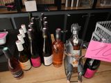 many bottles of wine on a table with a pink sign