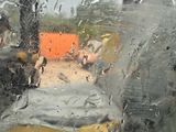 a picture of a view through a window of a bus on a rainy day
