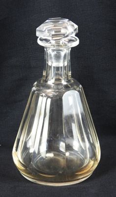 une bouteille en verre transparent munie d'un bouchon, sur fond noir