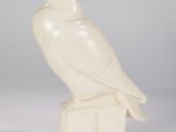 white owl figurine sitting on top of a wooden block