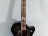 a black guitar with a gold design on it