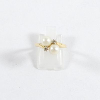 une image d'une bague en perles et diamants sur une surface blanche