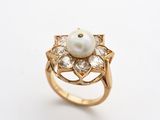 une image d'une bague en perles et diamants sur fond blanc