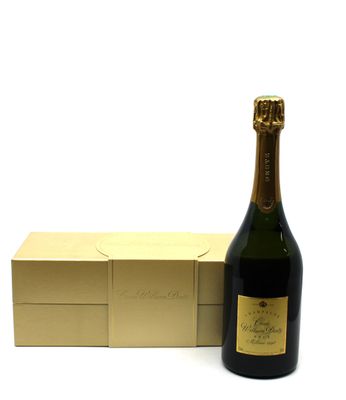 the bottle of champagne is next to a gold box on a white surface
