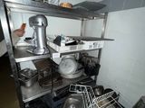 a man that is standing in a kitchen next to a shelf