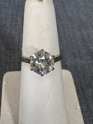 une bague sertie d'un diamant posée sur un présentoir à bagues
