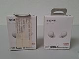 two boxes of sony earphones sitting on top of a table