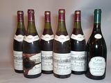 six bottles of wine are lined up in a row on a table