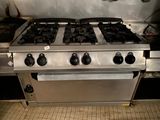 une cuisinière argentée équipée de quatre feux et de deux fours