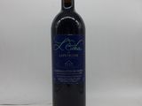 une bouteille de vin rouge posée sur une table blanche