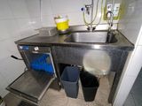 une cuisine équipée d'un évier, d'une poubelle et d'une poubelle à l'intérieur