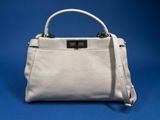 a white leather handbag on a blue background