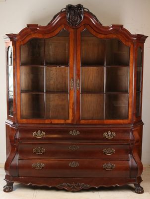 un vaisselier ancien en bois avec des portes vitrées et des tiroirs