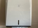 a paper towel dispenser on the wall in the bathroom