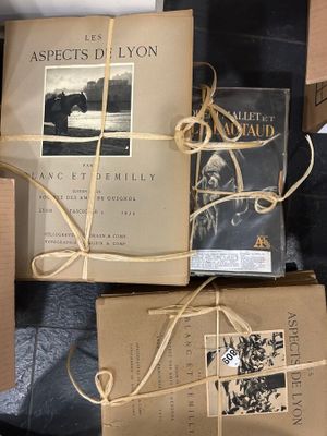 Plusieurs livres sont emballés dans du papier kraft et attachés avec de la ficelle.