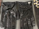 three pairs of black leather gloves with buttons on them on a table