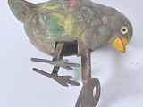 a metal bird that is sitting on a piece of metal