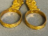 two pairs of gold colored scissors sitting next to each other on a table