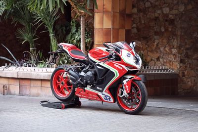 a red and black motorcycle parked in front of a building