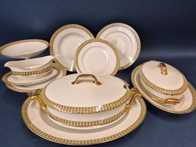 un service de vaisselle en porcelaine blanche et dorée, orné de bordures dorées