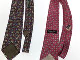 two ties with different designs on them on a white surface
