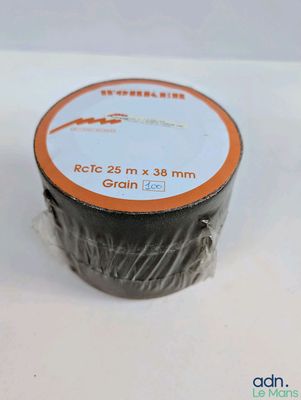 un rouleau de ruban adhésif noir sur une surface blanche