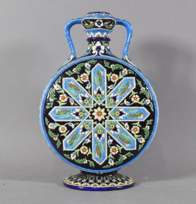 a blue and black vase with a floral design on it
