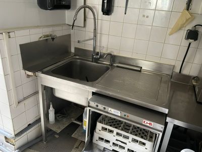 une cuisine équipée d'un évier et d'un lave-vaisselle