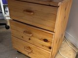 a wooden chest of drawers in the corner of a room