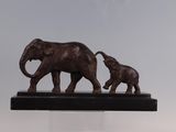 une statue représentant deux éléphants et un éléphanteau, posée sur un socle