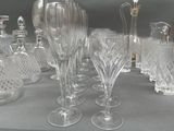 many glasses and vases sitting on a table