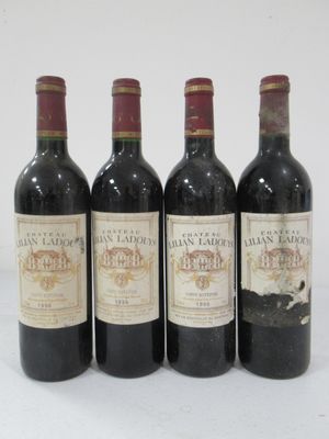 four bottles of wine are lined up in a row on a white surface