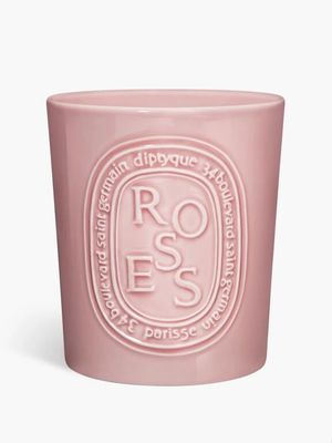 un gros plan d'une bougie rose sur fond blanc