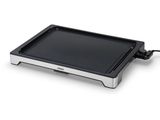 une image représentant une plaque de cuisson électrique noire et argentée sur fond blanc