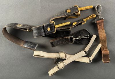 several different types of leather straps are laid out on a gray surface