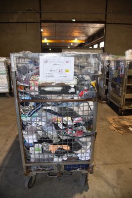 a metal cart with many items in it in a warehouse