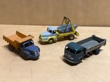 trois camions jouets assis l'un à côté de l'autre