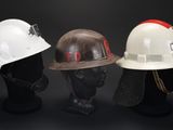 three hard hats that are sitting on top of a mannequin head