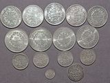 some silver coins are arranged in a row on a purple surface
