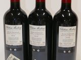 three bottles of wine sitting on top of a white table