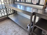a stainless steel table with a shelf underneath it