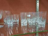 a lot of glasses on a glass shelf in a store