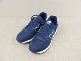 une paire de chaussures New Balance posée sur une surface blanche