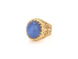 gros plan d'une bague en or avec une pierre bleue