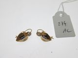 une paire de boucles d'oreilles dorées ornées de perles en verre transparent et d'une étiquette de prix
