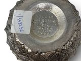a small silver bowl with a tag on it