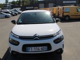 une Citroën blanche garée sur un parking